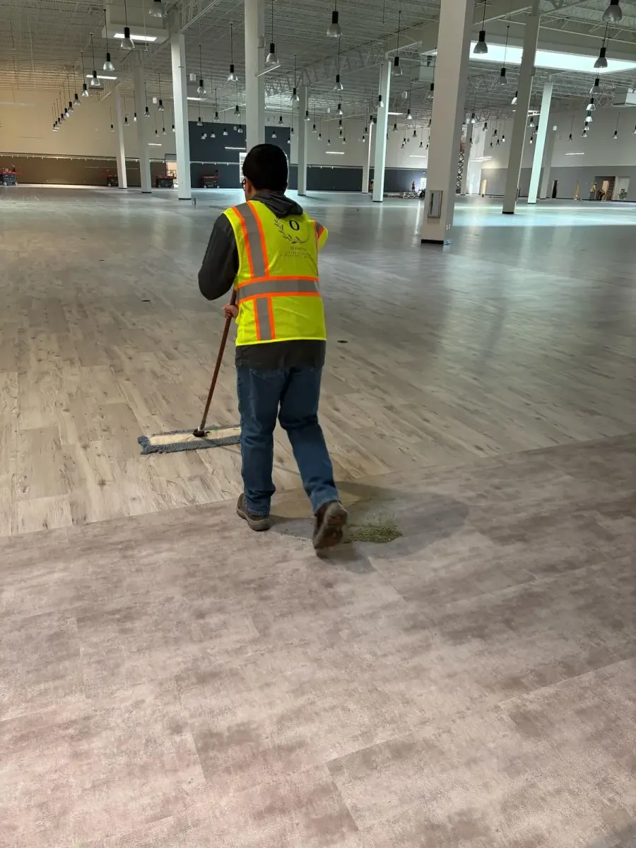 Olympus crew member mopping a warehouse floor during a final clean